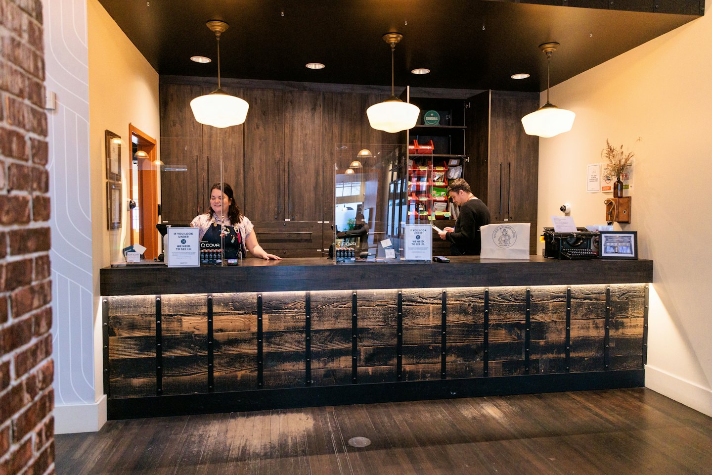 Business owner smiles behind reception desk during a client meeting.
